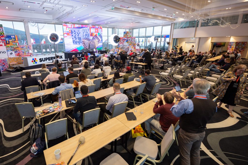 A conference room from Superweek with a room full of people waiting for the next industry expert talk.